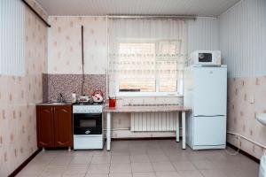 ピャチゴルスクにあるApartment Na Parkovoyの小さなキッチン(白い冷蔵庫付)、窓が備わります。