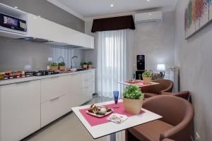 eine Küche mit einem Tisch, Stühlen und einer Theke in der Unterkunft Dreamsrome Suites in Rom