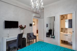 ローマにあるDreamsrome Suitesのベッド、デスク、テレビが備わる客室です。