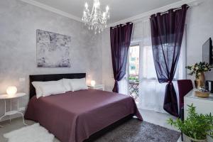 Dreamsrome Suites في روما: غرفة نوم بسرير ارجواني وثريا