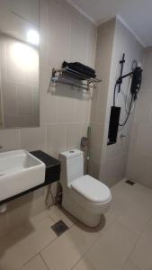 a bathroom with a white toilet and a sink at Eqino Swiss Garden Studio with Pool View in Kuantan