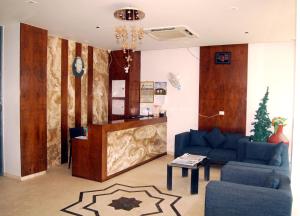a living room with a blue couch and a table at Hotel Apaar in Diu