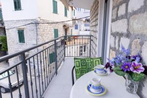 a balcony with a table with a vase of flowers at Apartments Kastilac near the beach in Kaštela