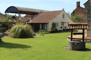 a house with a bench in front of a yard at Little England Retreats - Cottage, Yurt and Shepherd Huts in Othery