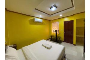 a room with a bed with yellow walls and a door at Casa Venicia Caticlan in Boracay