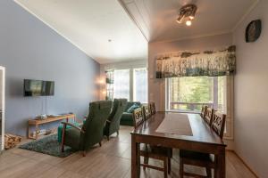 ルカにあるKotokuusi 1 - Huoneisto luonnon keskellä, sisältää siivouksen ja Wifinのテーブルと緑の椅子のあるダイニングルーム