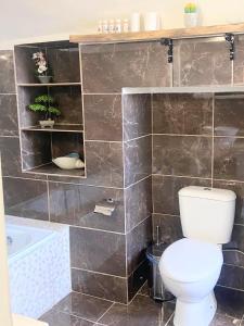 a bathroom with a toilet and a bath tub at ALEMINAS House 1 in Symi +41 photos
