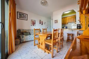 a kitchen and dining room with a table and chairs at CasitaRino in Puerto de Santiago