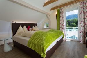 a bedroom with a bed and a large window at Smileys Seehäuschen in Seeboden