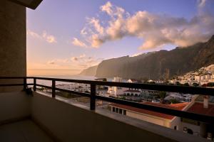 a balcony with a view of the ocean and mountains at CasitaRino in Puerto de Santiago