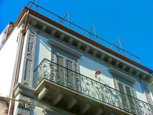 biały budynek z balkonem i niebieskim niebem w obiekcie Le dimore Al Vecchio Teatro w mieście Ortona