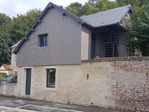 a house on a brick wall with a window at La boutique des Roches in Mondeville +7 photos