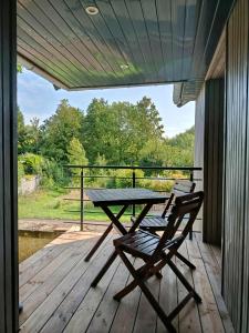 a picnic table and chairs on a deck with a view at La boutique des Roches in Mondeville