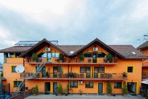 an orange building with a balcony with chairs at MAX International Hotel in Râşnov