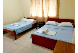 a room with two beds with towels on them at Moreno's Place in Boracay