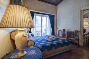 1 dormitorio con 1 cama con lámpara y ventana en Parione Suite Piazza Navona, en Roma