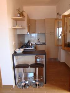 a kitchen with two bar stools and a stove at Casa Guerrino in Chiessi