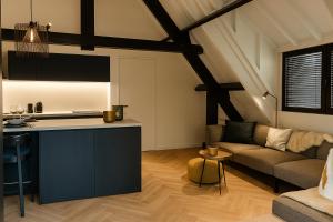 a kitchen and a living room with a couch at Cosy apartment with garden in Kortrijk