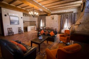 a living room with leather couches and a table at Casa Rural Casona la Beltraneja in Belmonte