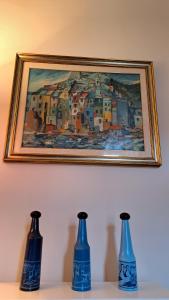 three blue vases sitting on a shelf under a painting at CAVOUR257 in La Spezia +42 photos