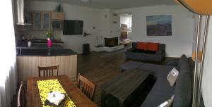 cocina y sala de estar con mesa y sofá. en Apartmán Pasohlávky en Pasohlávky