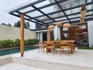 a patio with a table and chairs and a pool at Villa Anvaya in Pasuruan