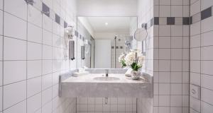 a white bathroom with a sink and a mirror at PLAZA INN Zwickau in Zwickau