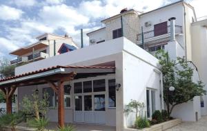 a white building with an awning in front of it at Apartments Dalmacija in Podstrana