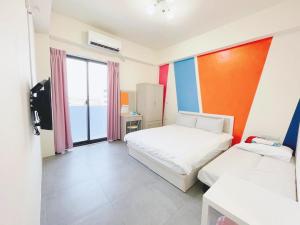 una stanza con due letti e una grande finestra di Penghu Happy House a Magong