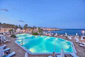 a large swimming pool next to the ocean at AluaSoul Menorca - Adults Only in S'Algar