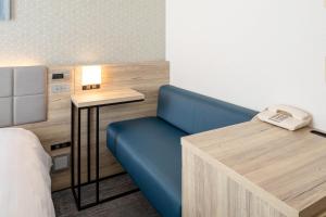a room with a blue couch and a desk with a phone at Comfort Hotel Hiroshima Otemachi in Hiroshima +32 photos