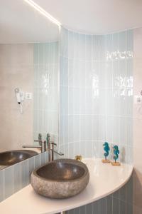 a bathroom with a large sink and a tub at Almar Suites in Peñíscola