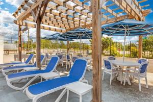 a group of chairs and tables with umbrellas at Quality Inn & Suites Spring Lake - Fayetteville near Fort Bragg in Spring Lake