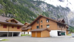 ein großes Holzgebäude mit einem Berg im Hintergrund in der Unterkunft Luxury Penthouse Apartment in Lauterbrunnen