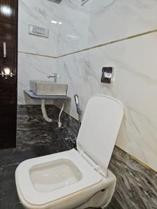 a bathroom with a white toilet and a sink at Nana's Farm and Resort in Jāmb