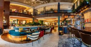 a restaurant with tables and chairs in a building at Canopy By Hilton Cape Town Longkloof in Cape Town