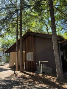 um prédio com árvores na frente em 西軽井沢小木屋 em Miyota