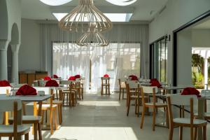 a dining room with tables and chairs and a chandelier at The Mirage Resort & SPA in Hammamet