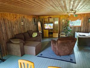 una sala de estar con un sofá y una silla en Barn House Mäntyniemi, en Hossa 28 fotos más