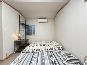 um quarto com uma cama em um quarto em 西軽井沢小木屋 em Miyota