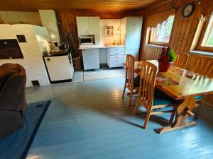 Una cocina y un comedor con mesa y sillas. en Barn House Mäntyniemi, en Hossa