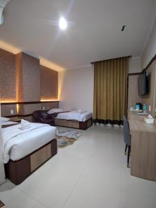 a hotel room with two beds and a television at Hotel Diana in Lhokseumawe +45 photos