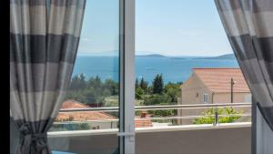 a view of the ocean from a balcony at Apartments ŽAJA in Seget Vranjica
