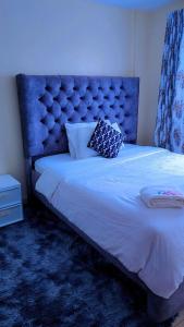 a bed with a blue headboard in a room at Blissful homes in Ruiru