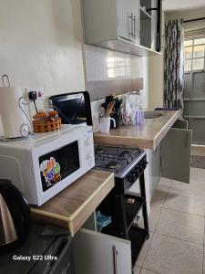 a kitchen with a microwave sitting on a counter at Blissful homes in Ruiru