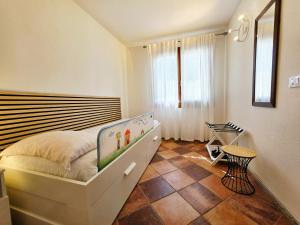 a small bedroom with a bed and a table at Dimora degli ulivi in Badesi