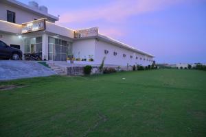 a large white building with a green lawn in front of it at Hotel Moon -Near Bus Stand Panipat in Pānīpat