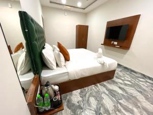 a hotel room with a bed and a flat screen tv at Kamari inn By Accu Hotel in Indore
