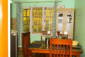 a dining room with a table and chairs and stained glass windows at Sisters Home & Apartment in Kathmandu