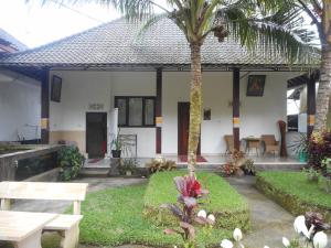 a house with a picnic table and a palm tree at Manik Villa Besakih in Besakih